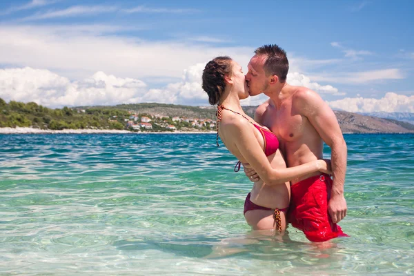Hübsches Paar küsst sich im Meer — Stockfoto