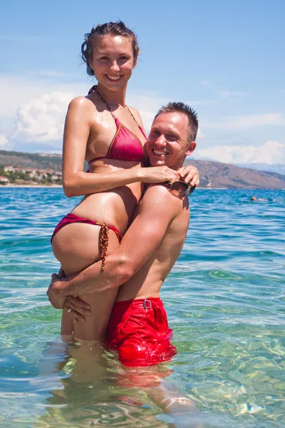 Hermosa pareja sonriente abrazándose en el agua —  Fotos de Stock