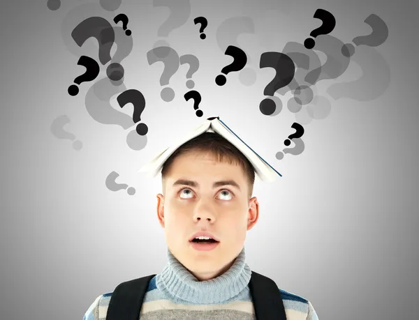Stressed student with question marks over his head — Stock Photo, Image