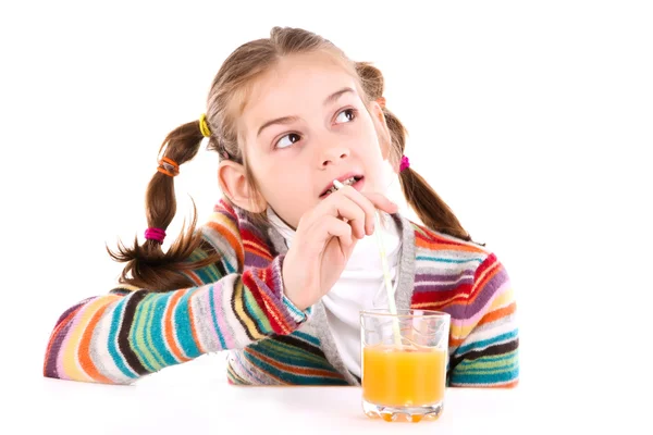 Маленькая девочка пьет апельсиновый сок — стоковое фото