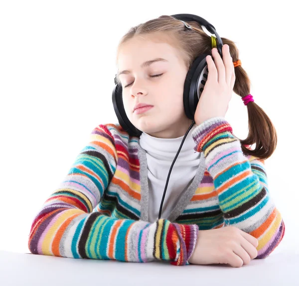 A kislány fülhallgatóban zenét hallgat. — Stock Fotó
