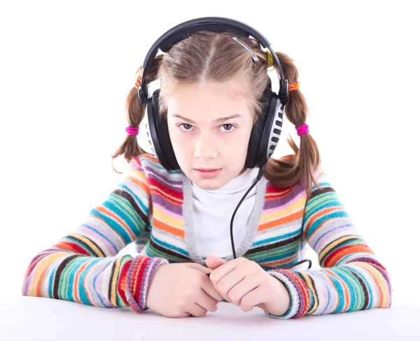 Glad liten flicka i hörlurar lyssnar på musik — Stockfoto