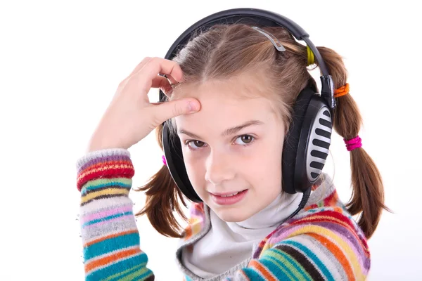 Felice bambina in cuffia ascolta la musica — Foto Stock