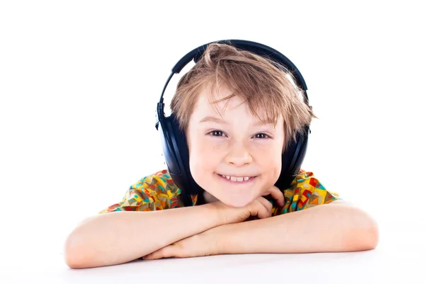 Porträtt av en söt ung pojke lyssna på musik i hörlurar — Stockfoto