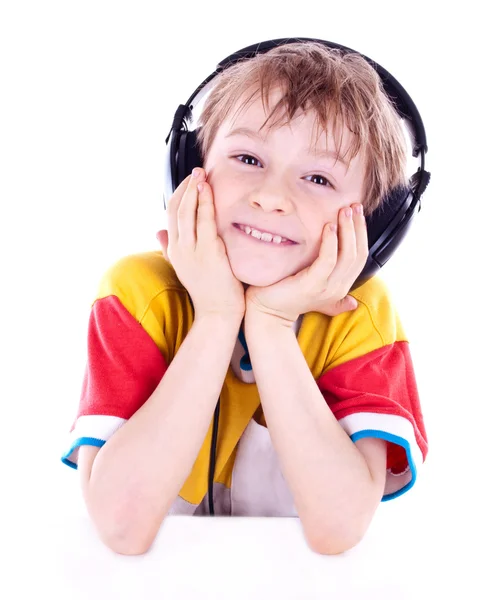 Portrait of a sweet young boy listening to music on headphones — Stock Photo, Image