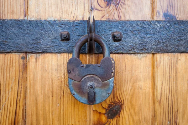 Cadeado enferrujado em uma velha porta de madeira — Fotografia de Stock
