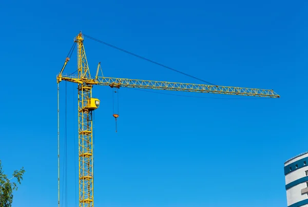 Sárga építési torony Crane ellen kék ég — Stock Fotó