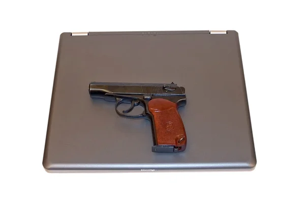 Пистолет лежит на ноутбуке — стоковое фото