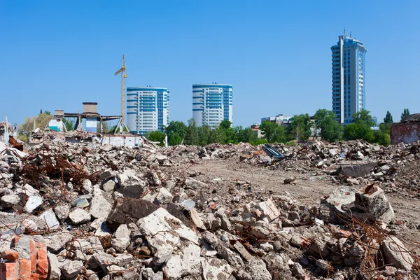 Mucchio di detriti di edificio in rovina su nuovi edifici sfondo — Foto Stock