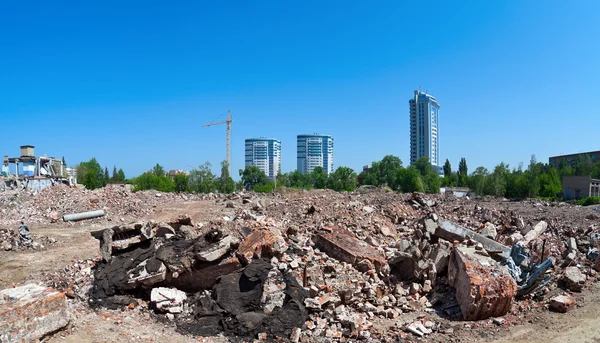 Pile of debris of ruined building on new buildings background — Stock Photo, Image