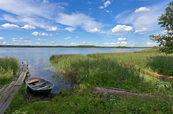 Paisagem do lago de verão com ponte de madeira e barco — Fotografia de Stock