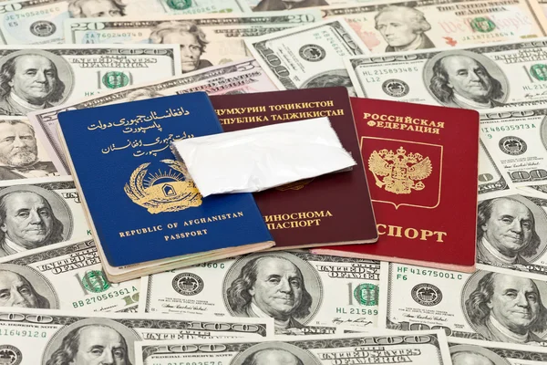 Paquete con una droga contra los pasaportes y dólares estadounidenses — Foto de Stock