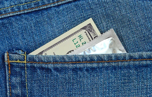 Dólares estadounidenses y condón en el bolsillo trasero de los vaqueros — Foto de Stock