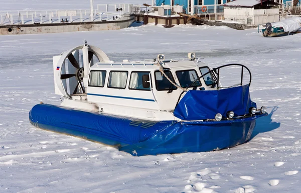 stock image Hovercraft crossing frozen river against a blue sky