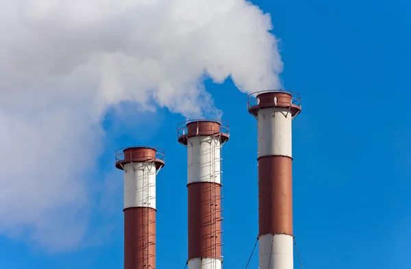 Lots of smoking chimneys other blue sky — Stock Photo, Image