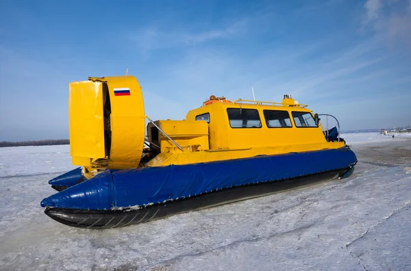 Hovercraft cruzando río congelado contra cielo azul —  Fotos de Stock