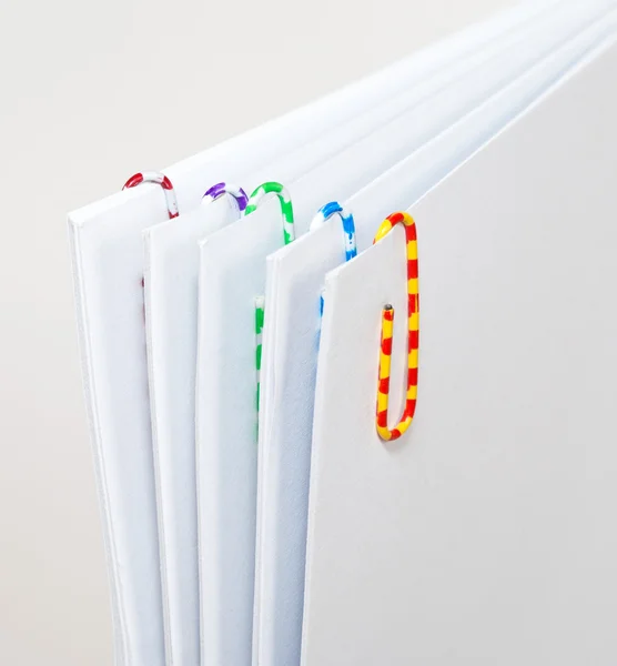 White sheets of paper with colorful paper clips — Stock Photo, Image