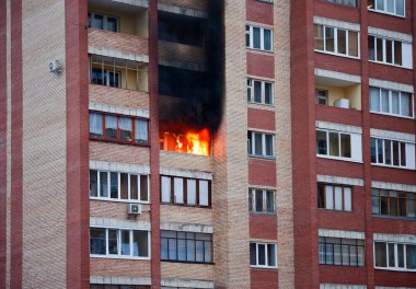 Fire in one of the apartments of a large tenement-house clipart