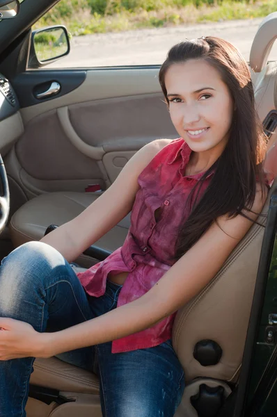 Beautiful brunette woman sitting in cabrio — Stock Photo, Image