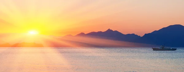 Sunset over sea and mountains — Stock Photo, Image