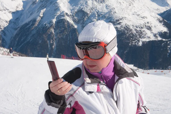 Skifahrer in den Bergen mit Handy in der Hand — Stockfoto