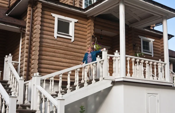 Женщина на балконе бревенчатого домика — стоковое фото