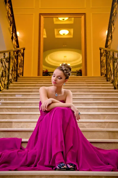 Frau im langen Kleid auf der Treppe liegend — Stockfoto