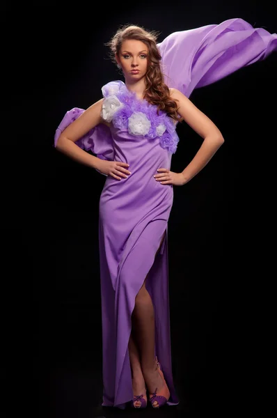 Красивая женщина в фиолетовом платье на сером фоне — стоковое фото