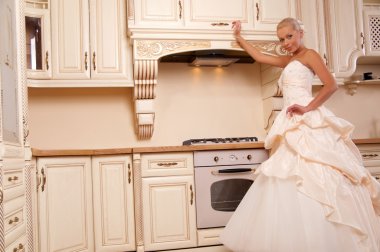 Beautiful bride stands in the kitchen clipart