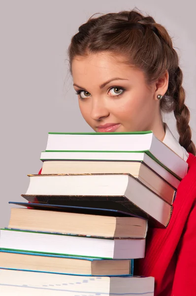 Девушка сидит перед книгами — стоковое фото