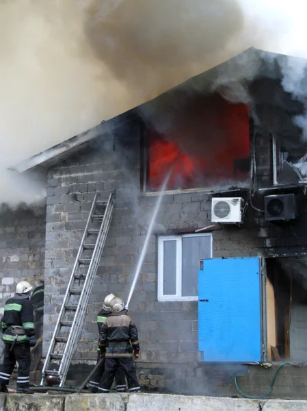 Brandweerlieden reageren op brand in een groot gebouw verzwolgen in — Stockfoto