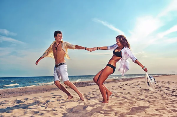 Jongen en meisje uitgevoerd op strand — Stockfoto