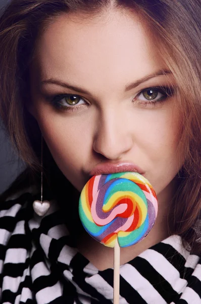 Vacker flicka suger söta på pinne — Stockfoto