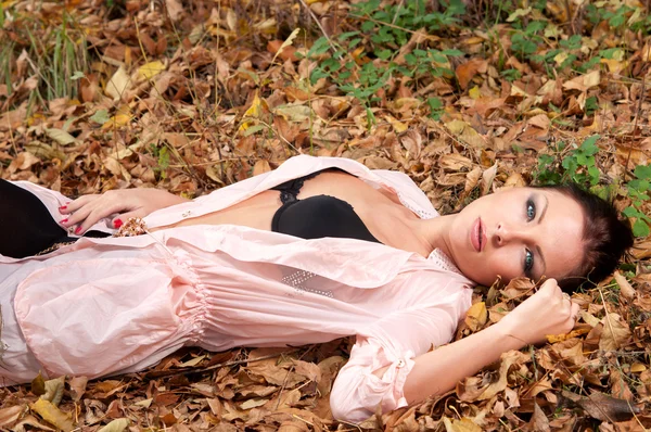 Mulher deitada nas folhas — Fotografia de Stock
