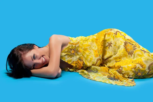Mulher deitada sobre um fundo azul — Fotografia de Stock