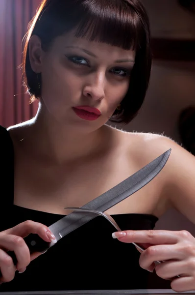 Kobieta w czarnej sukience z nożem — Zdjęcie stockowe