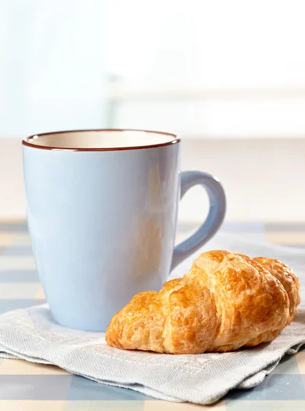 Croissant en thee beker — Stockfoto