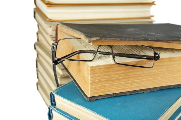 Hromadu starých knih a brýle izolovaných na bílém — Stock fotografie