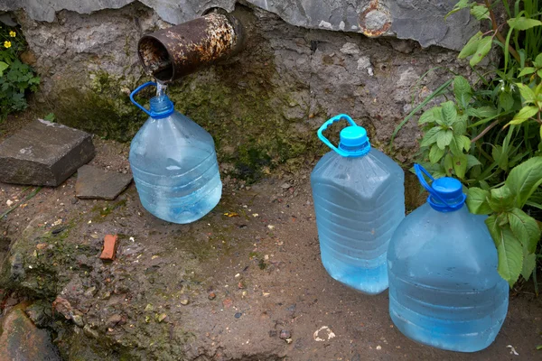 Flessen met water uit een bron — Stockfoto