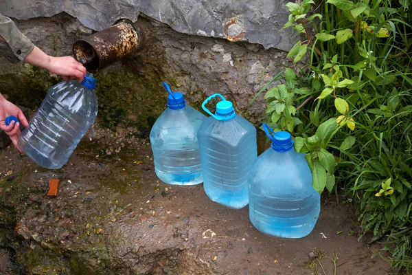 De vrouwelijke hand houdt plastic fles met water — Stockfoto