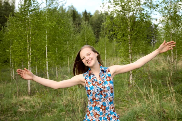 Girl has widely stretched hands against young birches — Stock Photo, Image