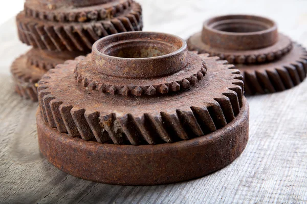 Rusty gear wheels on a board — Stock Photo, Image