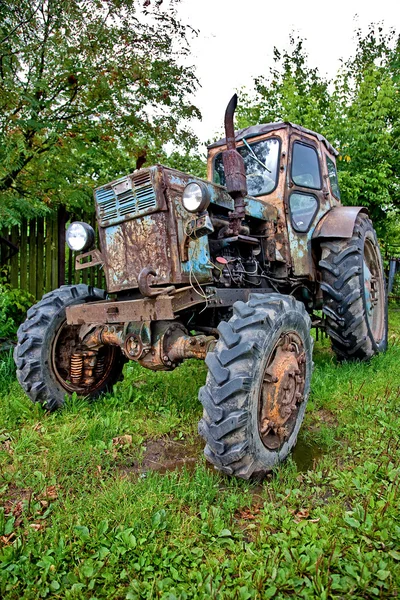 Старый трактор против деревьев — стоковое фото