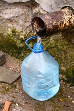 Filling bottle by spring water clipart