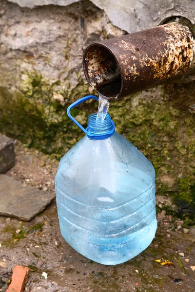 Vulling fles door bronwater — Stockfoto