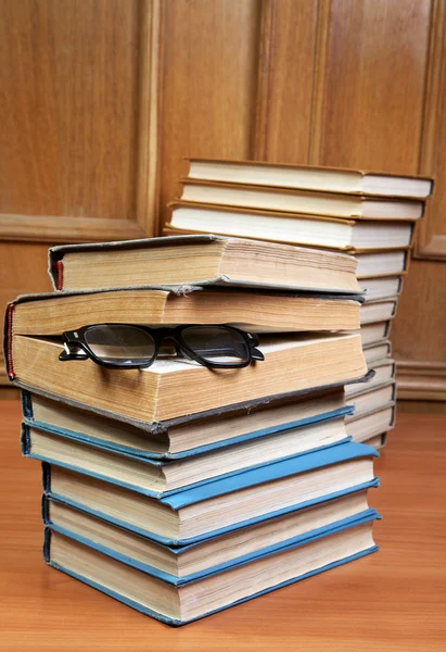 Två högar av gamla böcker och glasögon — Stockfoto