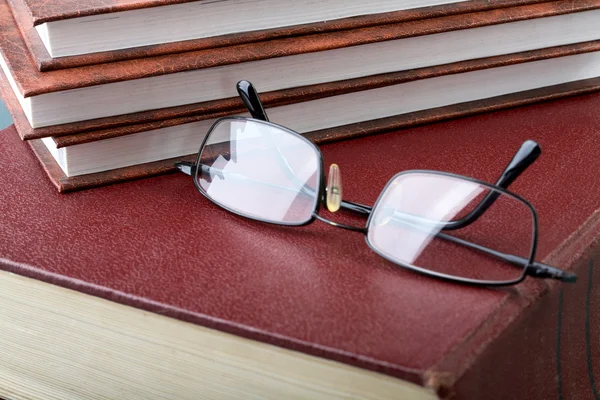 Hromadu knih a brýle na tlusté svazku — Stock fotografie