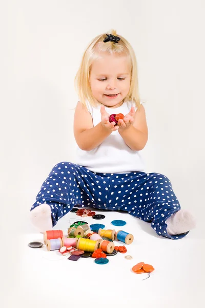 Дівчина грає з пряжею і кнопками — стокове фото