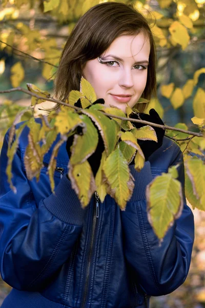 Улыбающаяся девушка среди осенних листьев — стоковое фото