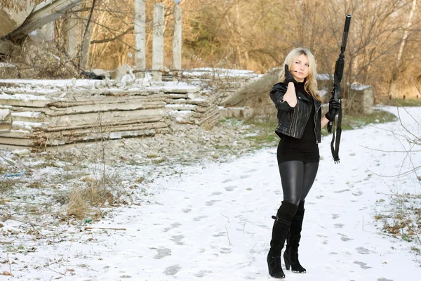 Nette junge Frau mit einer Waffe — Stockfoto